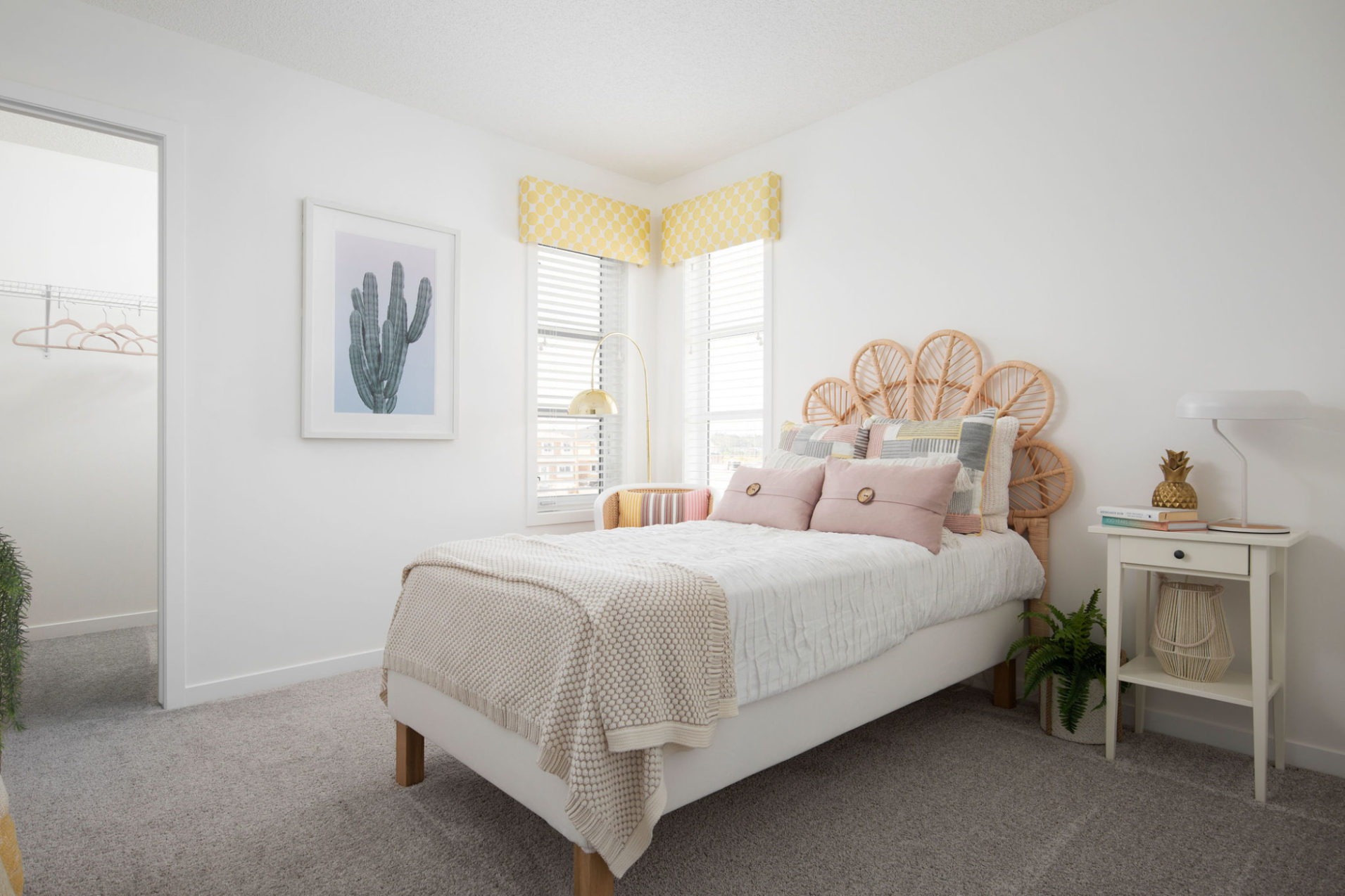 A carpeted bedroom with a child's bed and white walls.