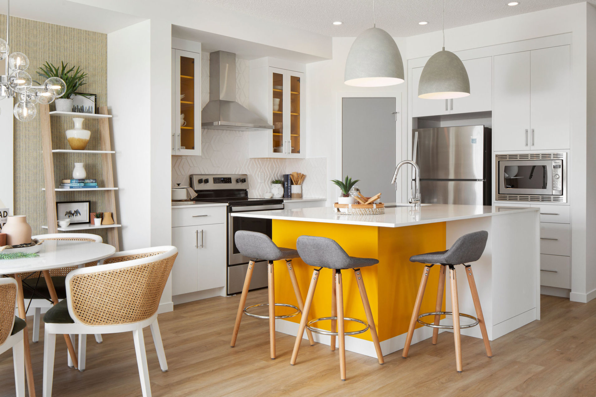 A kitchen with white cabinets, light wood floors, and yellow island.