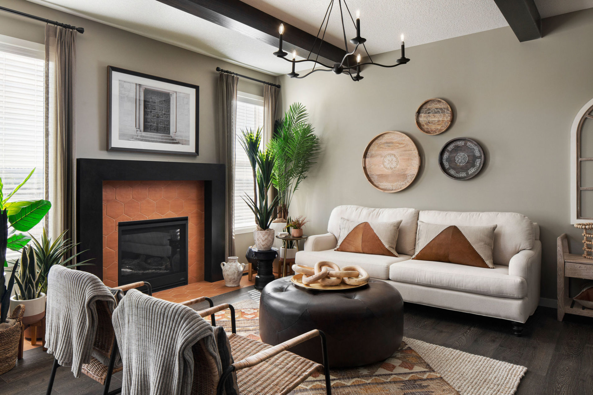 A living room with fireplace, white couch, and wooden ceiling beams.