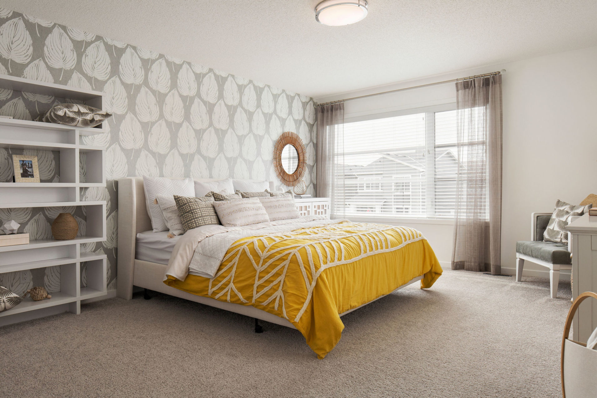 A furnished bedroom with a yellow bed spread and grey walls.