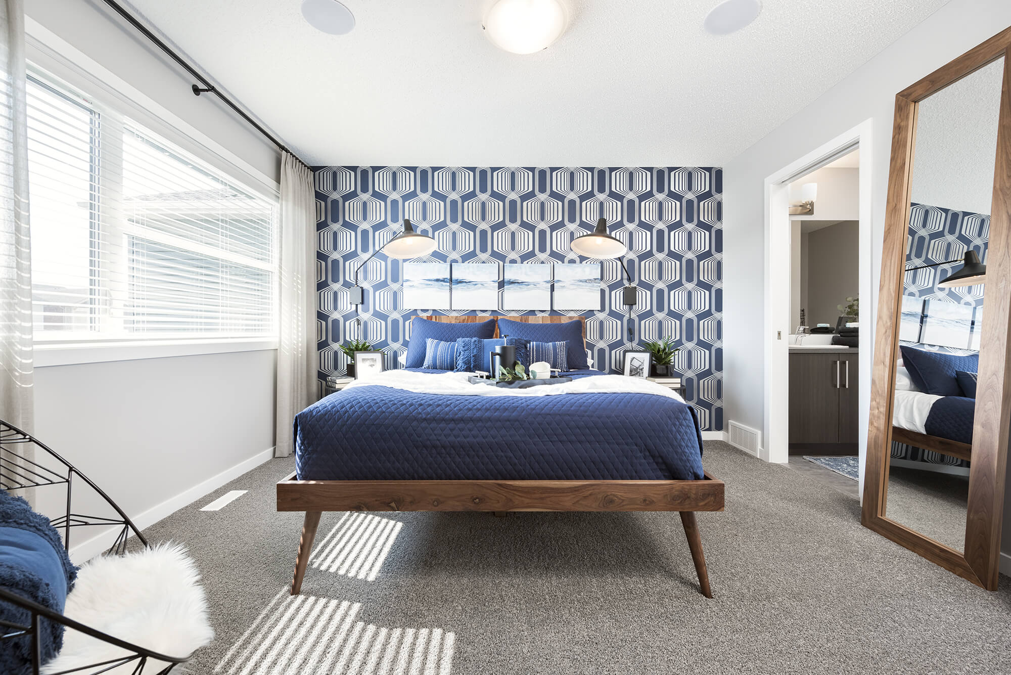 A furnished bedroom with a blue patterned statement wall.