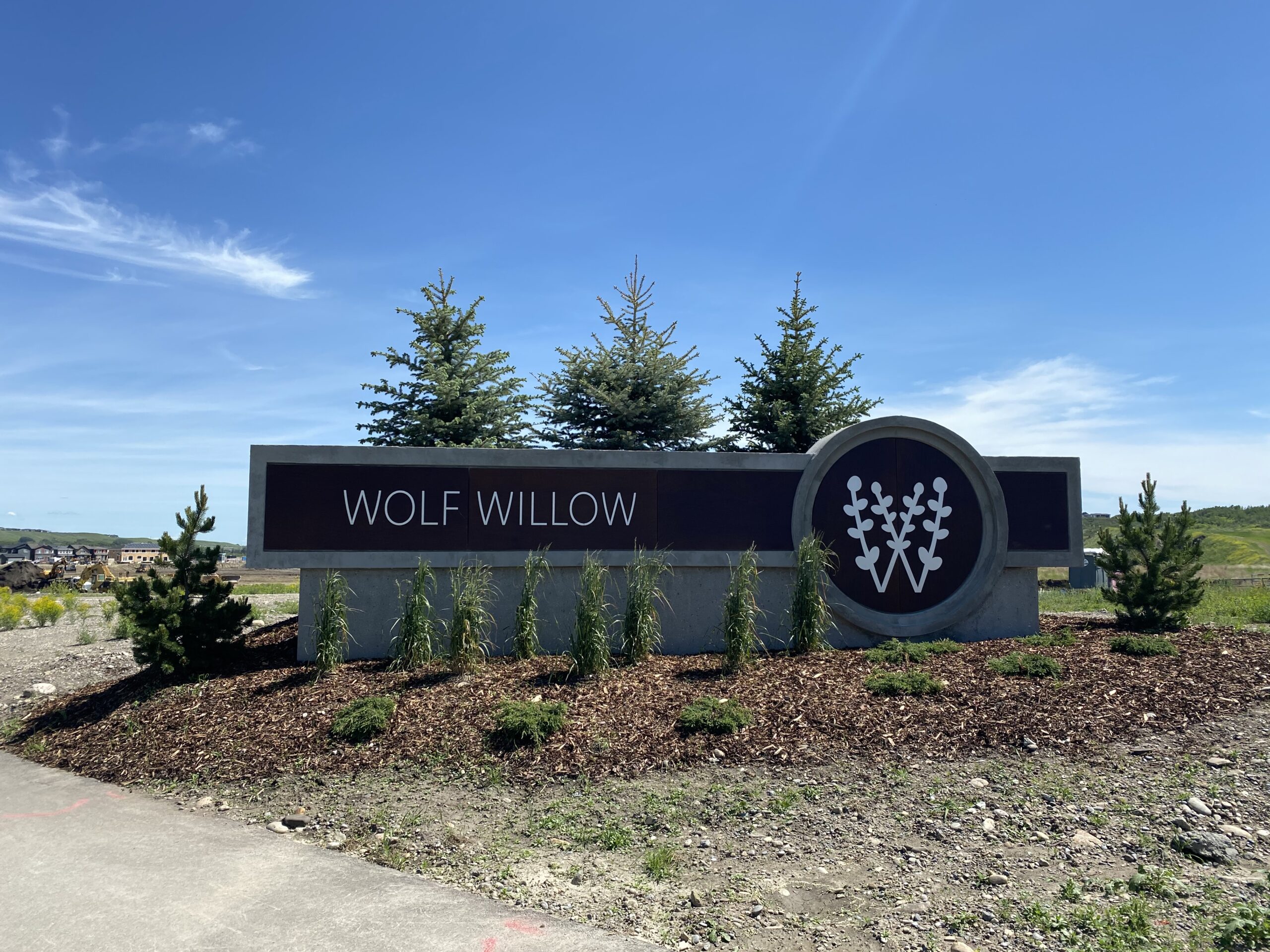 A concrete sign of the Wolf Willow logo and wordmark.