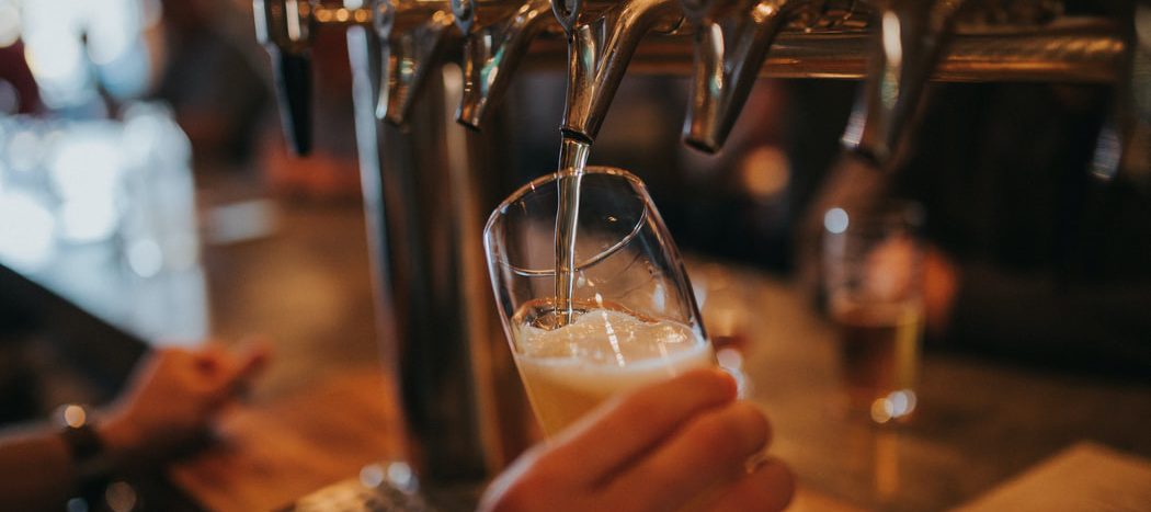 Beer is poured from a tap into a half-pint glass.