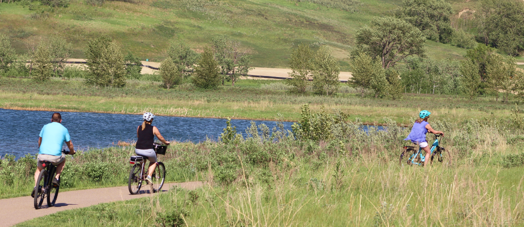 A person rides a bike along the Bow River in Wolf Willow.