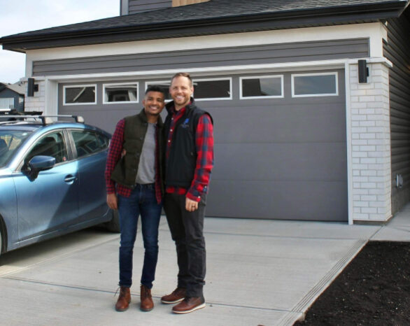 a happy couple standing outside of their new jayman front garage home