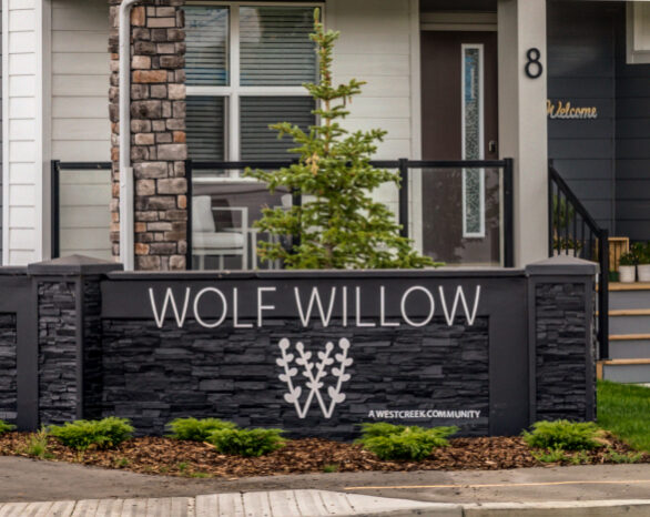 new "wolf willow" sign on a wall near the entrance to the community