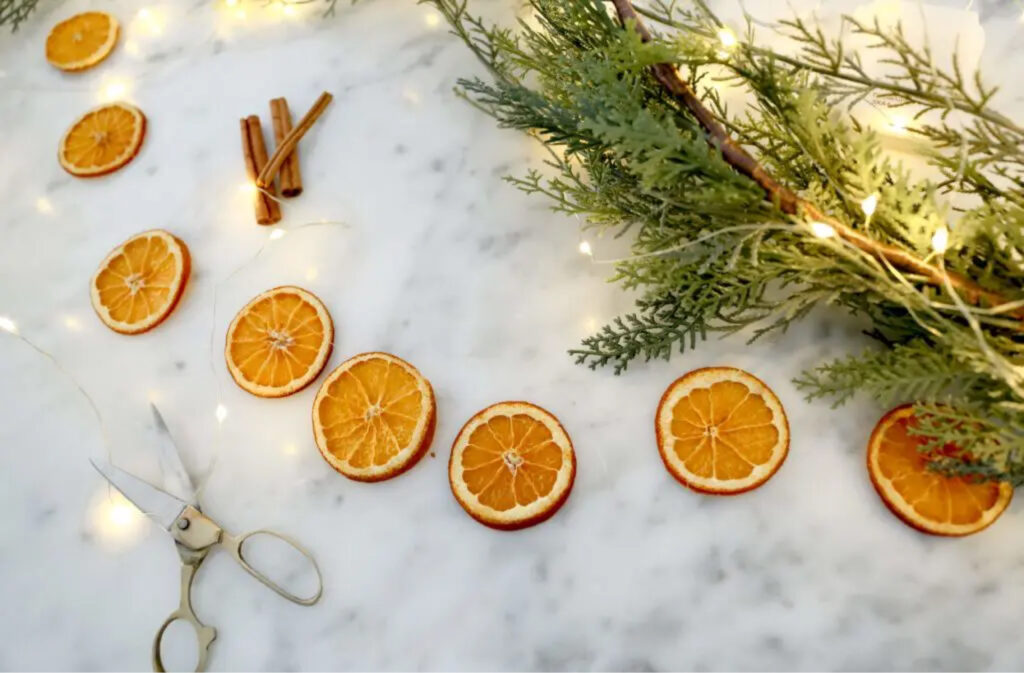 DIY garland with dried orange slices, twinkle lights, and scissors