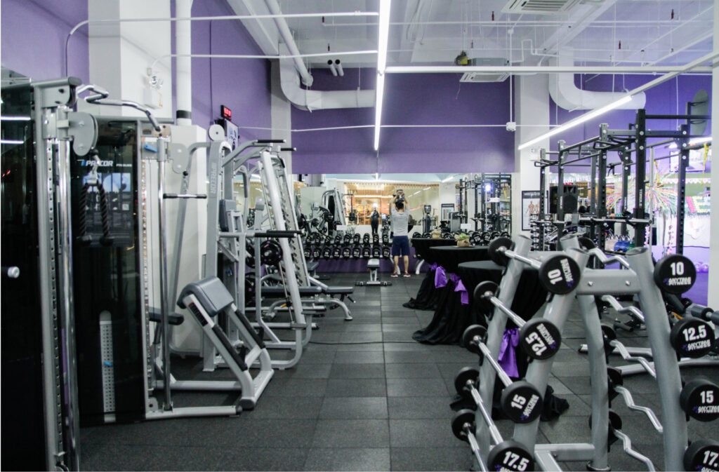 a gym interior with purple accents and lots of fitness machines