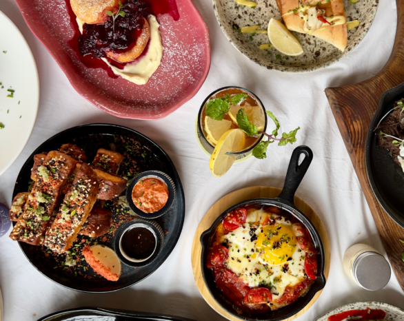 Variety of restaurant dishes on wooden table, representing South Calgary's diverse dining scene