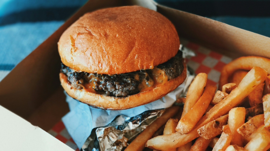 Smash burger and fries that you can eat at The Burger's Priest, a Canadian beef burger restaurant in Southpointe, South Calgary