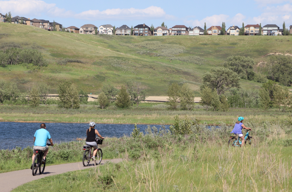 Cyclists biking along river pathways in Fish Creek Park, SE Calgary, by the Bow river