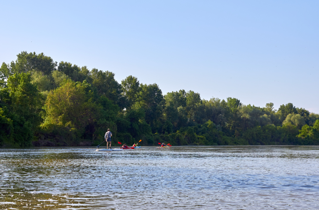 A raft and fishing boat floating down the Bow river in SE Calgary news to a golf course